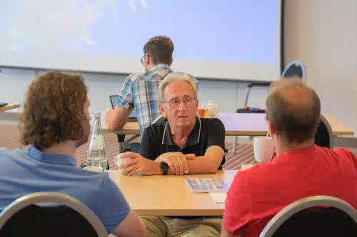 Peter Hruschka answers questions at the table in the training