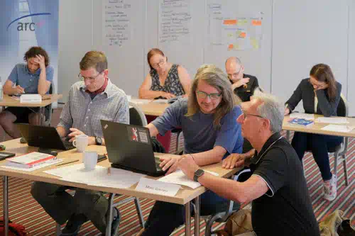 Peter Hruschka answers questions at the table in the training